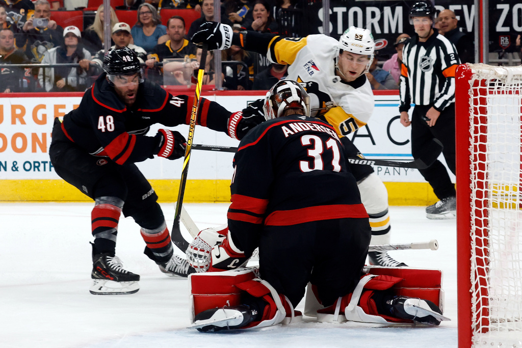 Pittsburgh Penguins' Egor Chinakhov shoots the puck at Carolina Hurricanes goaltender Frederik Andersen (31) with Jordan Martinook (48) nearby during the first period of an NHL hockey game in Raleigh, N.C., Tuesday, March 10, 2026. (AP Photo/Karl DeBlaker)