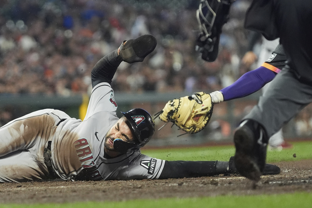 Arizona Diamondbacks' Jordan Lawlar, left, slides home to score past San Francisco Giants catcher Patrick Bailey during the fifth inning of a baseball game in San Francisco, Tuesday, Sept. 9, 2025. (AP Photo/Jeff Chiu)