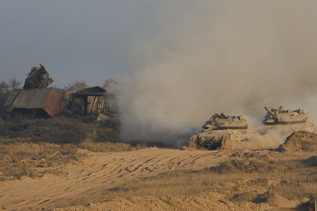 Israeli soldiers drive tanks inside Gaza Strip towards southern Israel, Sunday, Oct. 5, 2025. (AP Photo/Ariel Schalit)