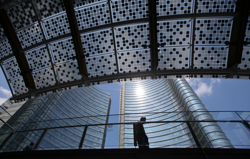 FILE - A man walks in the Porta Nuova urban district in Milan, Italy, on April 22, 2016. (AP Photo/Luca Bruno, File)
