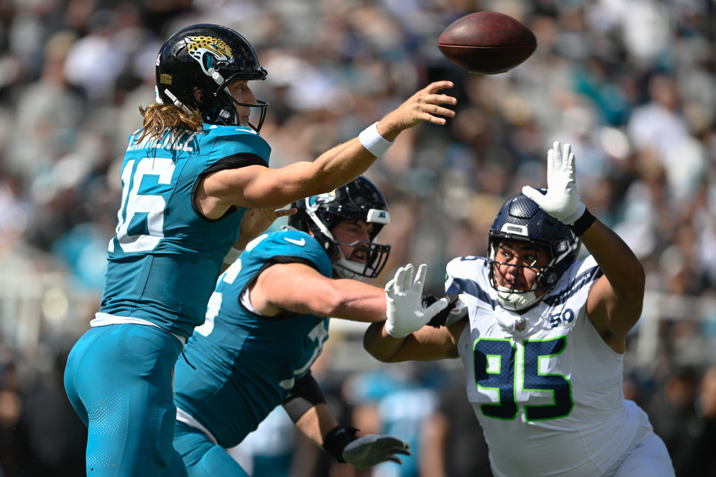 Jacksonville Jaguars quarterback Trevor Lawrence (16) throws in front of Seattle Seahawks' Brandon Pili (95) during the first half of an NFL football game Sunday, Oct. 12 2025, in Jacksonville, Fla. (AP Photo/Phelan M. Ebenhack)