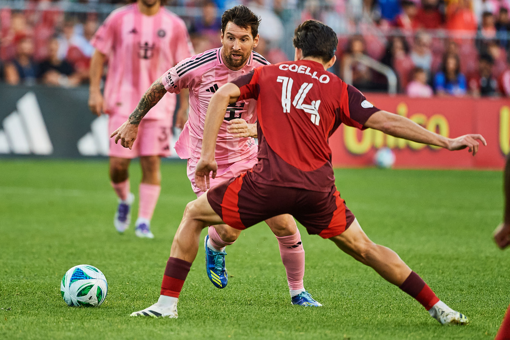 Inter Miami's Lionel Messi (10) moves the ball as Toronto FC's Alonso Coello (14) defends during the second half of a MLS soccer game, Saturday, Sept. 27, 2025, in Toronto. (Sammy Kogan/The Canadian Press via AP)