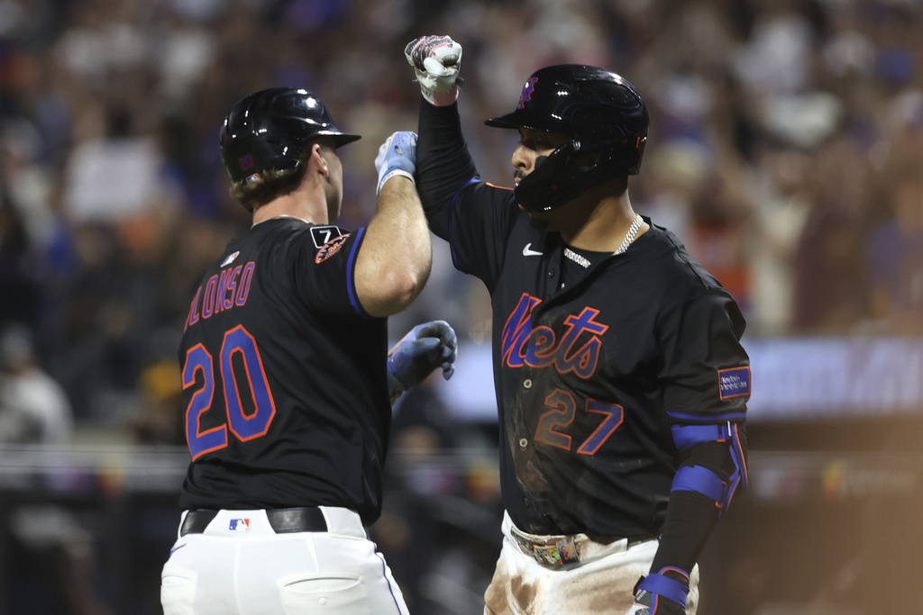New York Mets' Pete Alonso, left, and Mark Vientos, right, react after Alonso hit a two-run home run which also scored Juan Soto during the second inning of a baseball game against the Miami Marlins, Friday, Aug. 29, 2025, in New York. (AP Photo/Pamela Smith)
