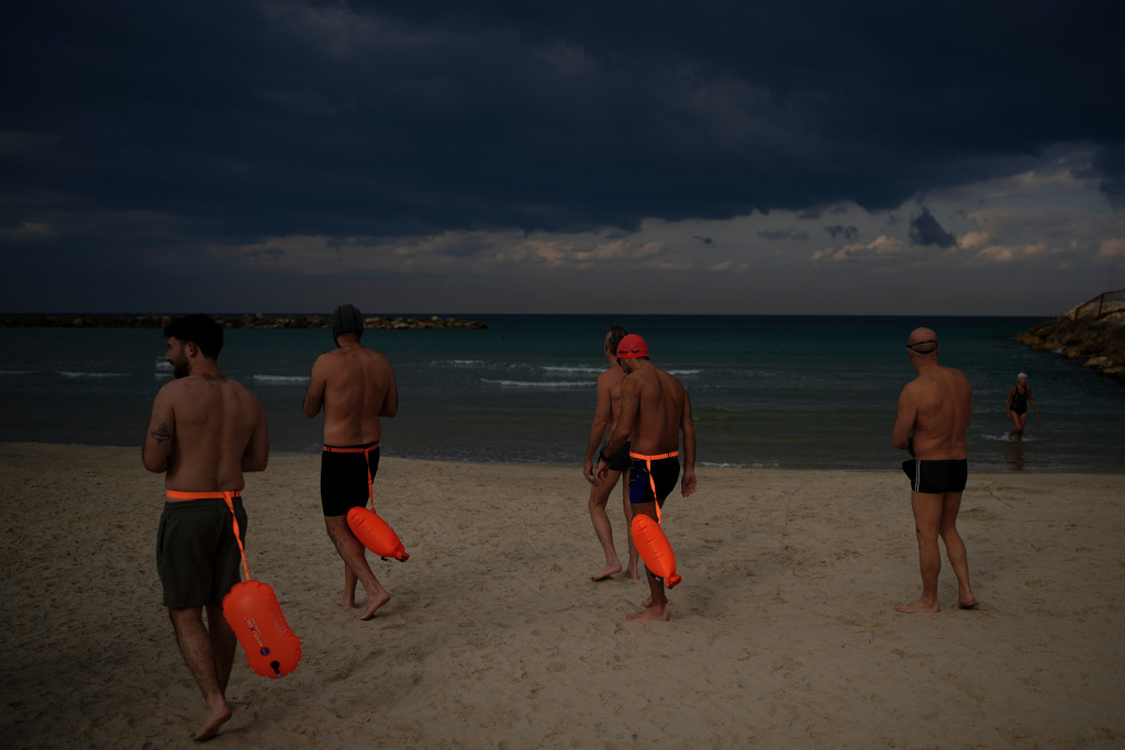 Swimmers enter the Mediterranean Sea in Tel Aviv, Israel, Wednesday, March 4, 2026. (AP Photo/Ohad Zwigenberg)
