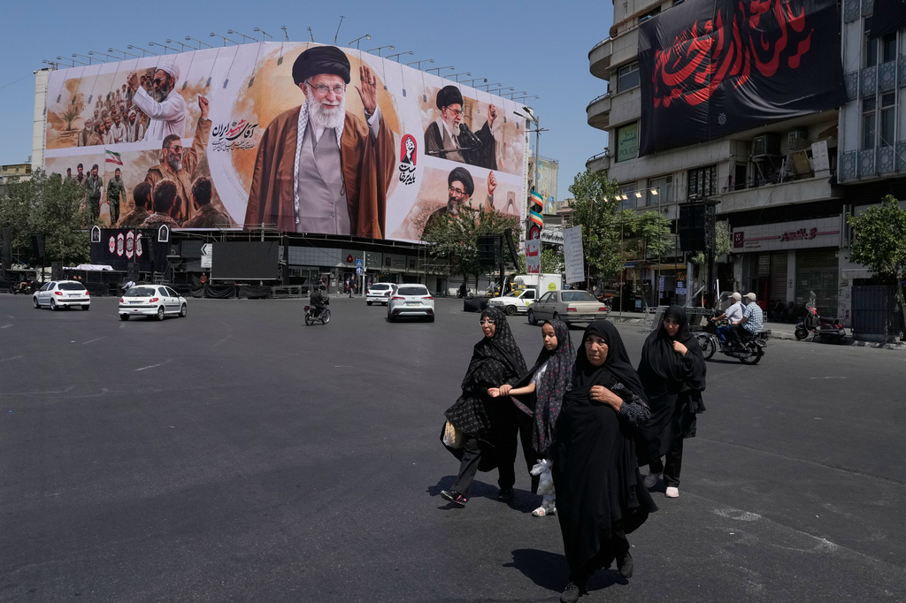 People walk past a billboard showing the late Iranian Supreme Leader Ayatollah Ali Khamenei in Islamic Revolution Square in Tehran, Iran, Sunday, July 5, 2026. (AP Photo/Vahid Salemi)