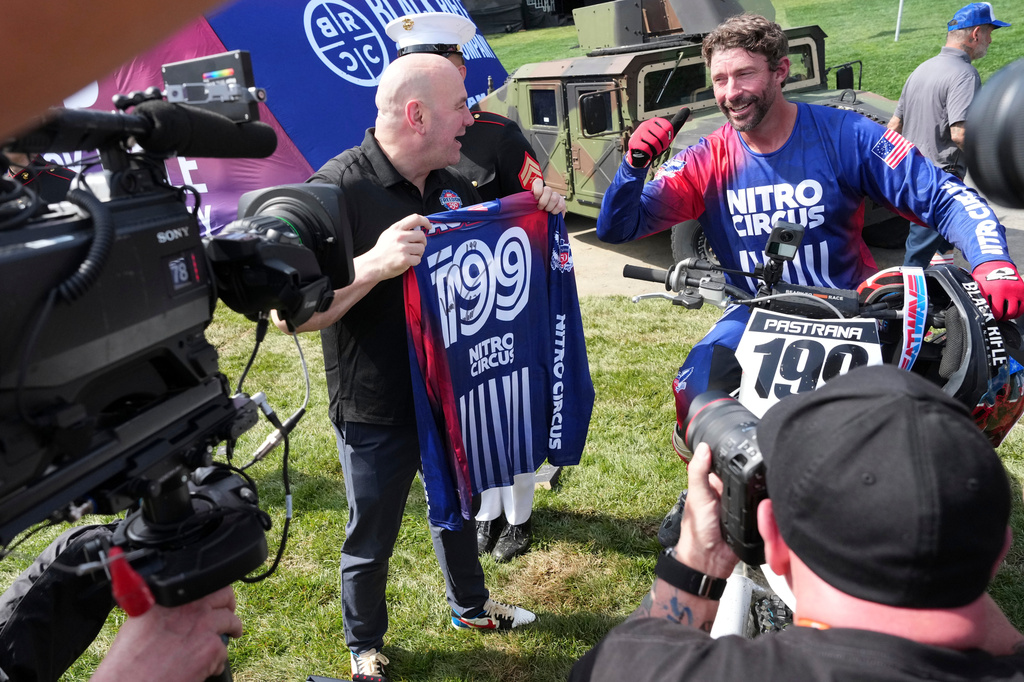 UFC President and CEO Dana White holds the jersey of Travis Pastrana alongside Pastrana following a motorcycle jump ahead of the UFC Freedom 250 fights on the South Lawn of the White House, Saturday, June 13, 2026, in Washington. (AP Photo/Alex Brandon, Pool)