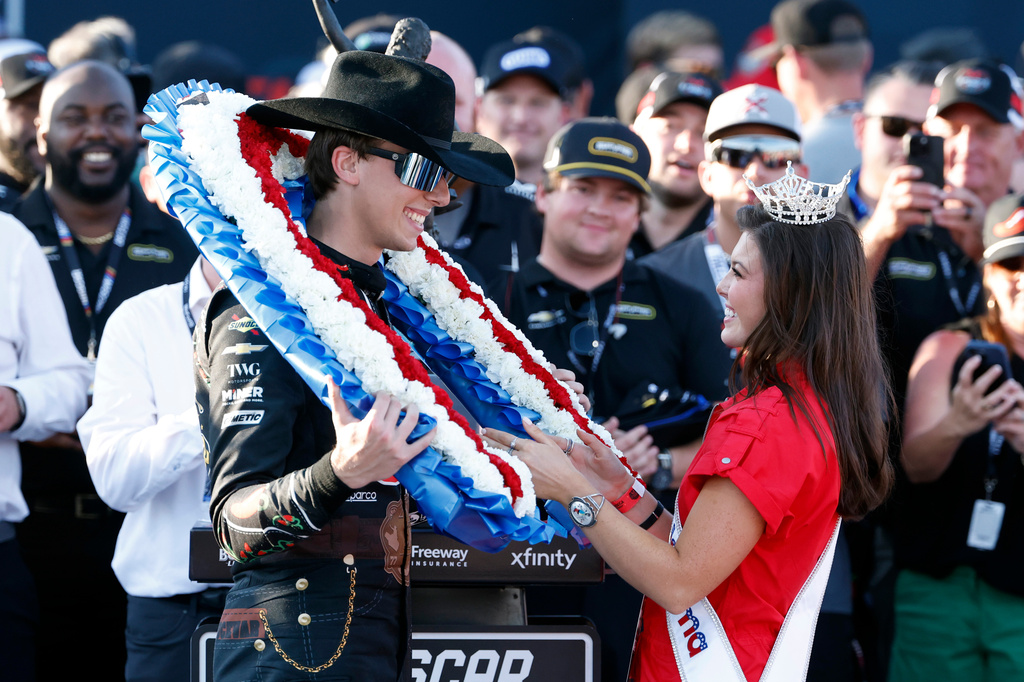 Carson Hocevar is presented a wreath from Miss Alabama Hailey Adams after winning a NASCAR Cup Series auto race, Sunday, April 26, 2026, in Talladega, Ala. (AP Photo/Butch Dill)