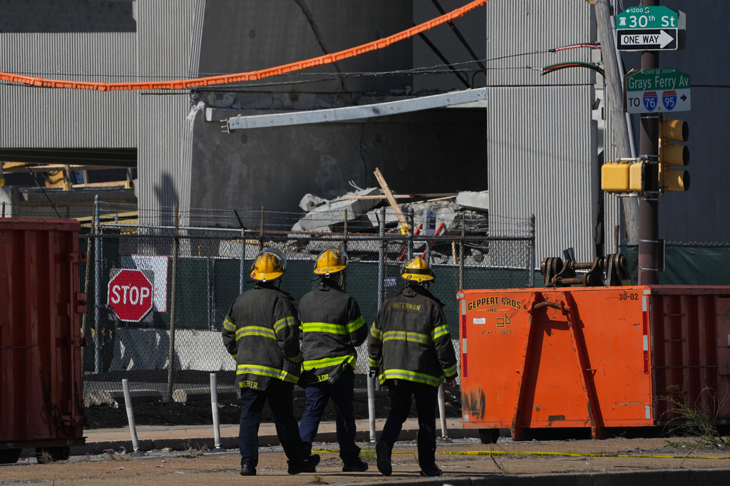 First responders walk near a partially collapsed parking garage in Philadelphia, Thursday, April 9, 2026. (AP Photo/Matt Rourke)
