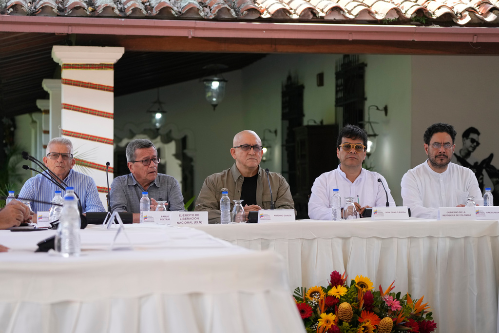 FILE - Members of the Colombian guerrilla National Liberation Army (ELN), from left, Aureliano Carbonel, Pablo Beltran and Antonio Garcia sit with Ivan Danilo Rueda, High Commissioner for Peace on behalf of the Colombian government, second from right, and government representative Ivan Cepeda, during a signing ceremony agreeing to resume peace talks, at the Casa Cultural Aquiles Nazoa in Caracas, Venezuela, Oct. 4, 2022. (AP Photo/Ariana Cubillos, File)