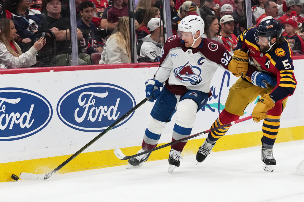 Colorado Avalanche left wing Gabriel Landeskog (92) skates with the puck as Florida Panthers defenseman Donovan Sebrango (6) defends during the first period of an NHL hockey game, Sunday, Jan. 4, 2026, in Sunrise, Fla. (AP Photo/Lynne Sladky)