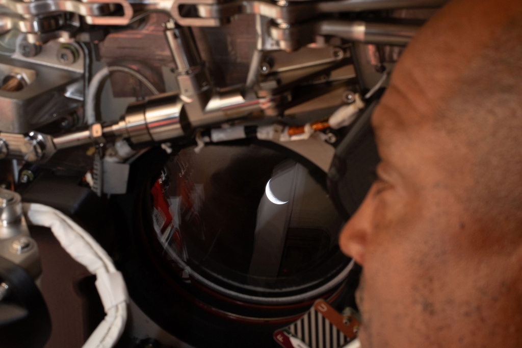 In this photo provided by NASA, Artemis II pilot and NASA astronaut Victor Glover peers out one of the Orion spacecraft's windows looking back at Earth ahead of the crew's lunar flyby, Monday, April 6, 2026.(NASA via AP)