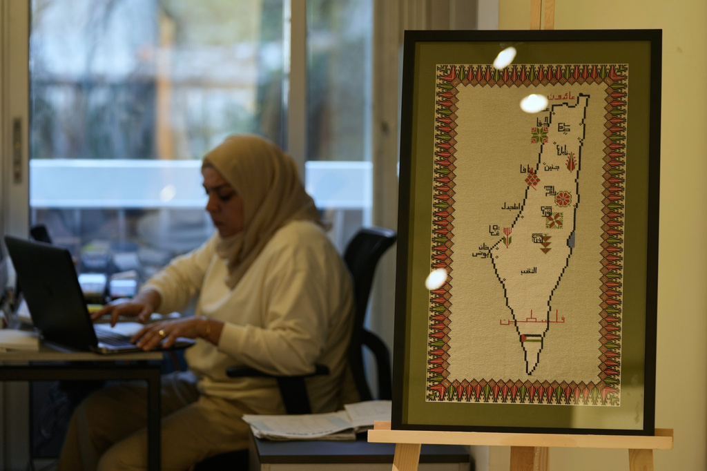 A hand-embroidered map of historic Palestine with names of cities and the words “Palestine” and “Returning” in Arabic is displayed at the Inaash Association embroidery workshop in Beirut, Tuesday, May 19, 2026. (AP Photo/Bilal Hussein)
