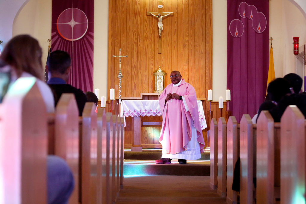 FILE - The Rev. Athanasius Abanulo, from Nigeria, celebrates Mass at Holy Family Catholic Church in Lanett, Ala., on Sunday, Dec. 12, 2021. He is one of numerous international clergy helping ease a U.S. priest shortage by serving in Catholic dioceses across the country. (AP Photo/Jessie Wardarski, File)