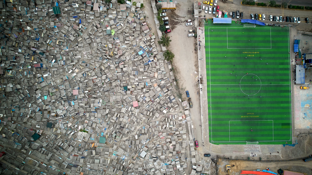 Residents play soccer alongside the Belaunde cemetery in the Comas neighborhood in Lima, Peru, Sunday, July 12, 2026. (AP Photo/Martin Mejia)