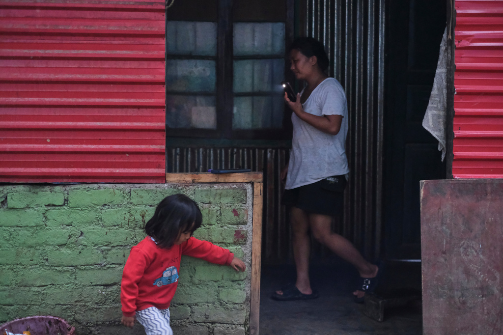 Atoshi Ayemi, 27, walks past her daughter Azatina, as she helps with cooking dinner in Kohima, capital of the northeastern Indian state of Nagaland, Monday, July 6, 2026. (AP Photo/Yirmiyan Arthur)