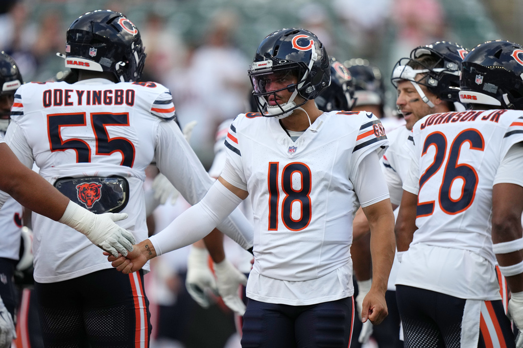 Chicago Bears quarterback Caleb Williams, center, greets players during warm ups before a preseason NFL football game against the Cincinnati Bengals on Saturday, Aug. 22, 2026, in Cincinnati. (AP Photo/Joshua A. Bickel)
