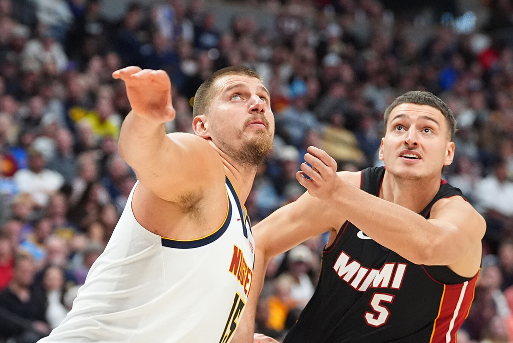 Denver Nuggets center Nikola Jokic, left, jostles for position or a rebound with Miami Heat forward Nikola Jovic in the first half of an NBA basketball game Wednesday, Nov. 5, 2025, in Denver. (AP Photo/David Zalubowski)