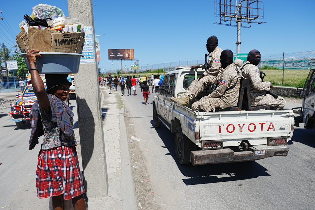 National Police patrol as factory workers march demanding a salary increase in Port-au-Prince, Haiti, Tuesday, April 14, 2026. (AP Photo/Odelyn Joseph)