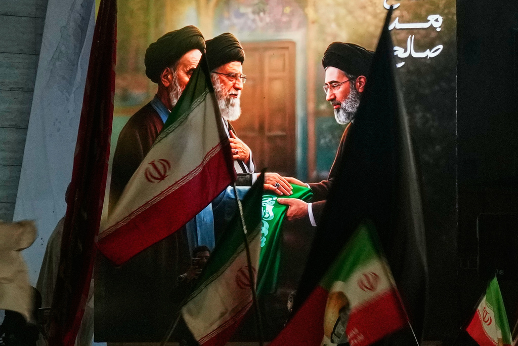 Protesters wave Iranian flags and hold a portrait of the late Iran's Supreme Leader Ayatollah Ali Khamenei and his son Ayatollah Mojtaba Khamenei to support his selection as the new Iran's Supreme Leader in Baghdad, Monday, March 9, 2026. (AP Photo/Hadi Mizban)