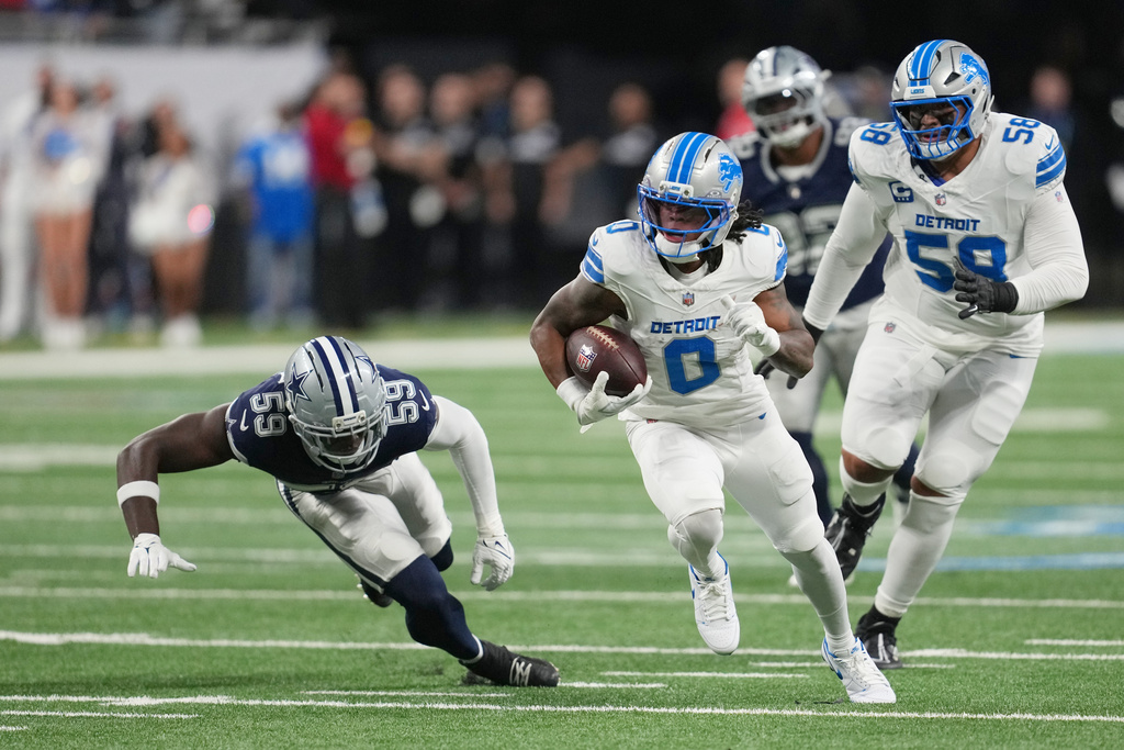 Detroit Lions running back Jahmyr Gibbs (0) runs the ball as Dallas Cowboys linebacker Jr. Kenneth Murray (59) tries to stop him during the first half of an NFL football game Thursday, Dec. 4, 2025, in Detroit. (AP Photo/Paul Sancya)