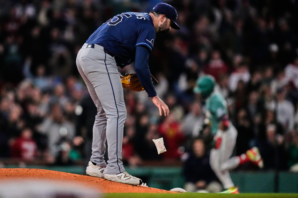 Tampa Bay Rays pitcher Jesse Scholtens drops the rosin bag while preparing a fresh baseball as Boston Red Sox's Ceddanne Rafaela, right, rounds the bases on a solo home run in the fourth inning during a baseball game against the Tampa Bay Rays, Friday, May 8, 2026, in Boston. (AP Photo/Charles Krupa)