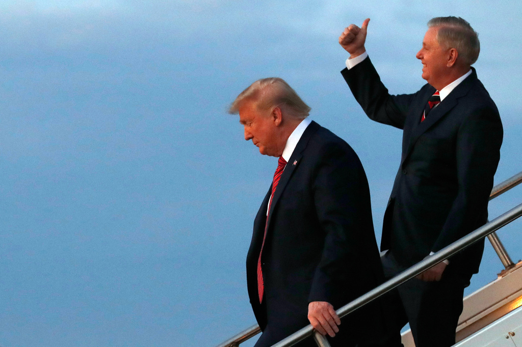 FILE - President Donald Trump, left, exits Air Force One with Sen. Lindsey Graham, R-S.C., Feb. 28, 2020, on arrival to North Charleston, S.C., where he will attend a campaign rally. (AP Photo/Jacquelyn Martin, File)