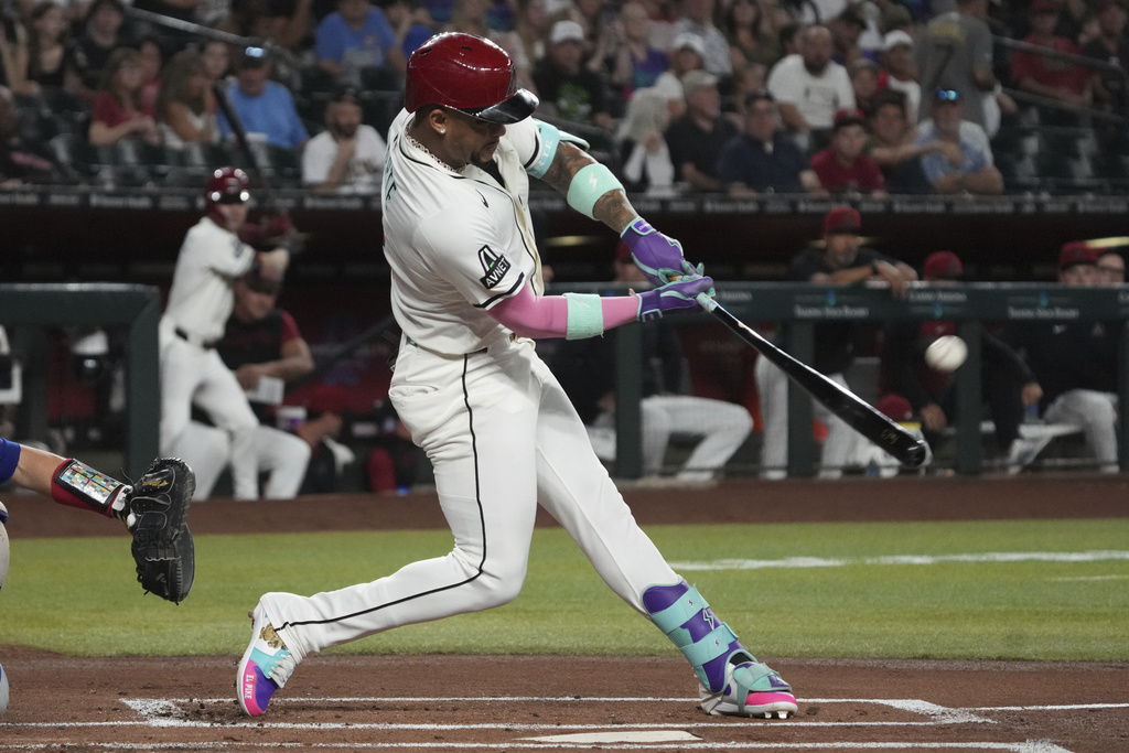 Arizona Diamondbacks' Ketel Marte hits a solo home run against the Texas Rangers in the first inning of a baseball game, Monday, Sept. 1, 2025, in Phoenix. (AP Photo/Rick Scuteri)
