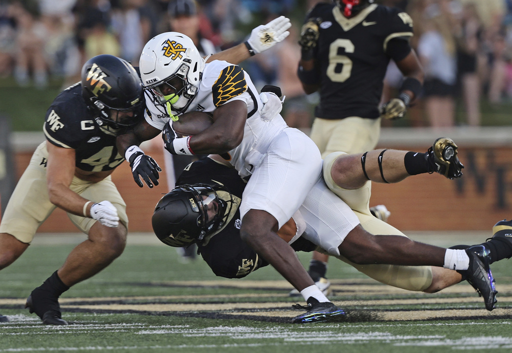 Wake Forest defensive back Nick Andersen (left) and linebacker Dylan Hazen take down Kennesaw State running back Coleman Bennett in the first half of an NCAA football game on Friday, Aug. 29, 2025 at in Winston-Salem, N.C. (Walt Unks/The Winston-Salem Journal via AP)