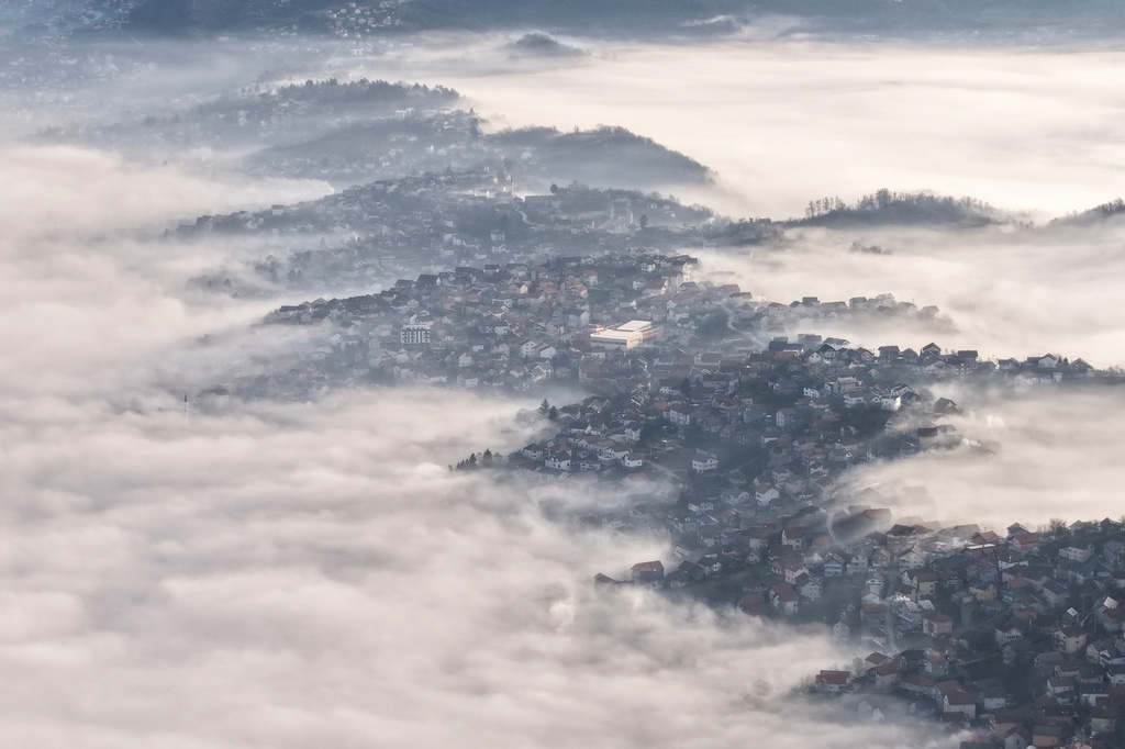 An aerial view of houses blanketed by a dense layer of fog in Sarajevo, Bosnia, Thursday, Dec. 18, 2025. (AP Photo/Armin Durgut)