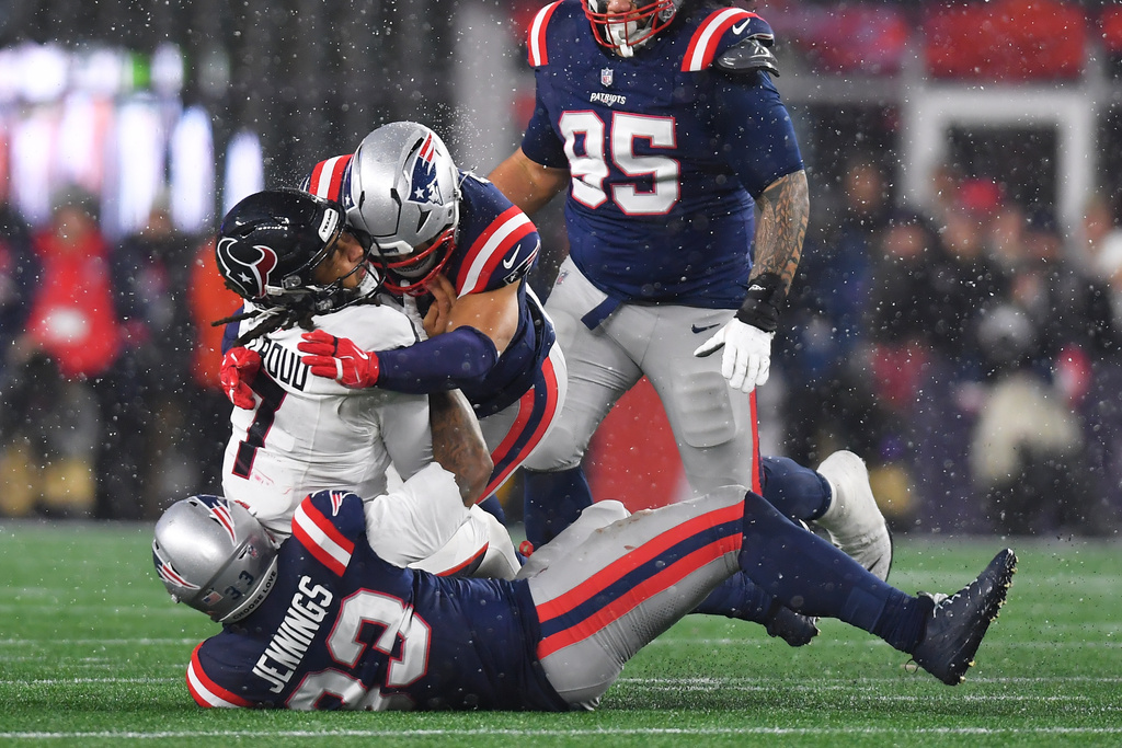 Houston Texans quarterback C.J. Stroud (7) is tackled by New England Patriots linebacker Anfernee Jennings, bottom, and linebacker Christian Elliss during the second half of an NFL divisional playoff football game, Sunday, Jan. 18, 2026, in Foxborough, Mass. (AP Photo/Steven Senne)
