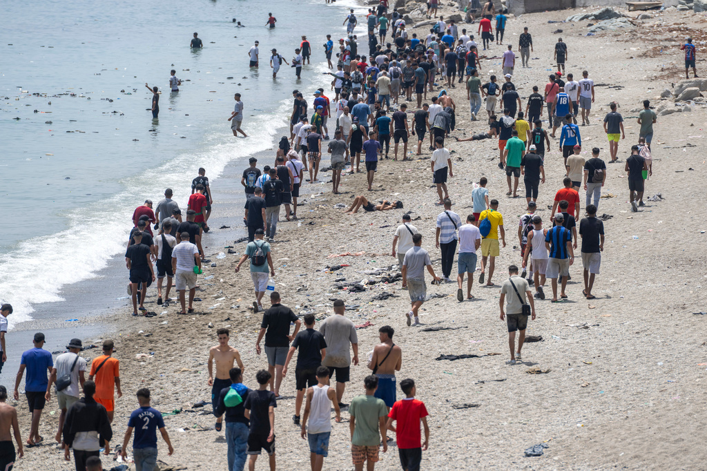 FILE - People walk on a beach after attempting to cross from the Moroccan northern town of Fnideq to the Spanish enclave of Ceuta, July 31, 2026. (AP Photo, File)