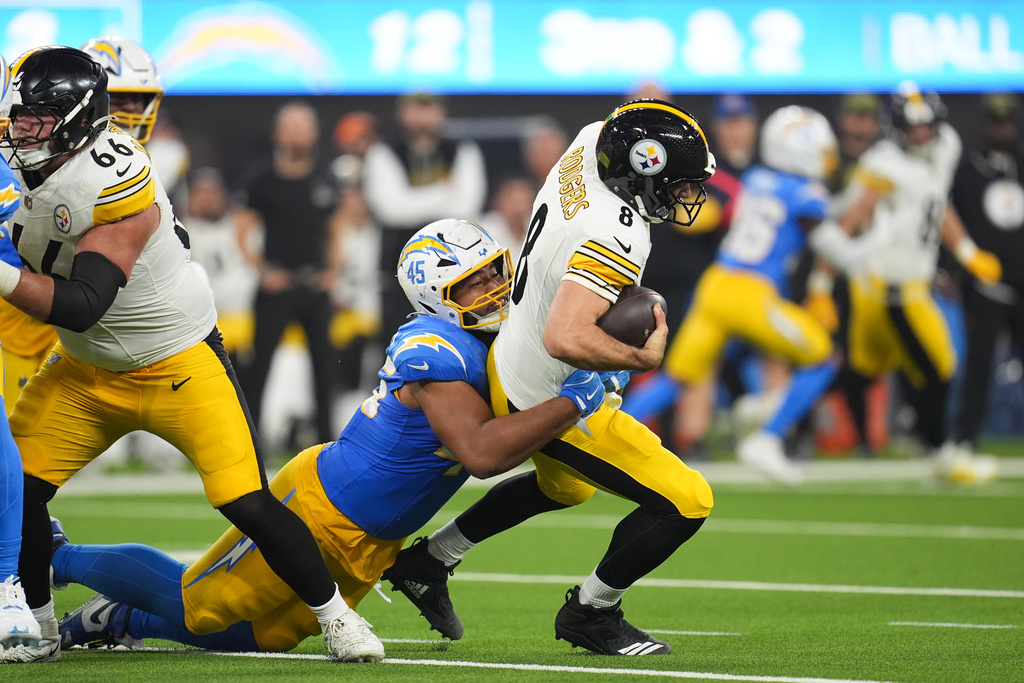 Pittsburgh Steelers quarterback Aaron Rodgers (8) is sacked by Los Angeles Chargers linebacker Tuli Tuipulotu (45) during the second half of an NFL football game Sunday, Nov. 9, 2025, in Inglewood, Calif. (AP Photo/Marcio Jose Sanchez)