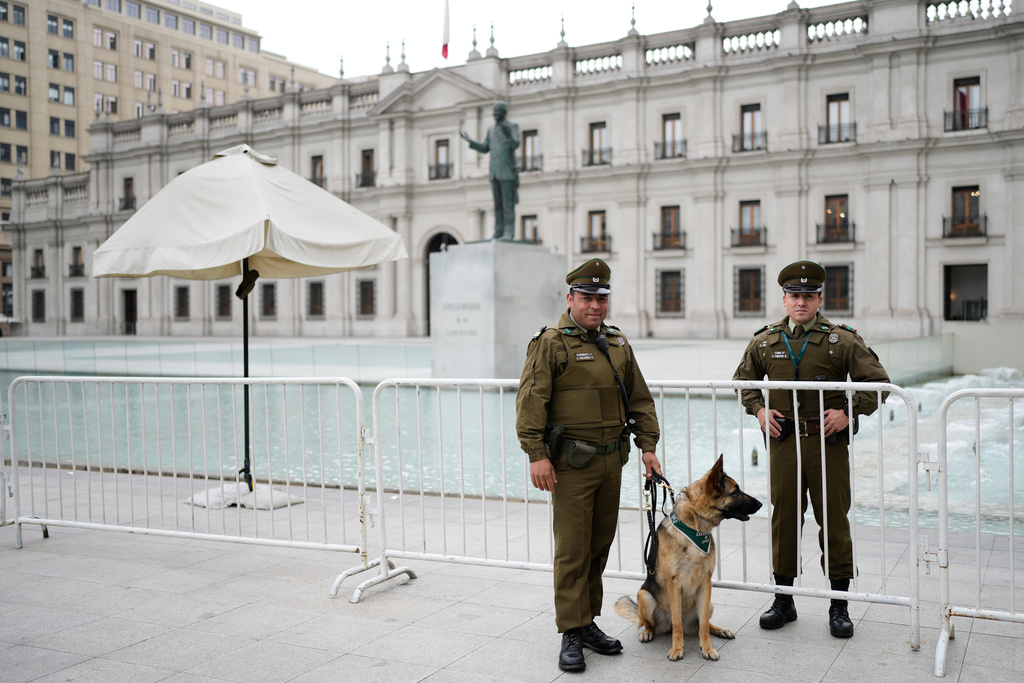 Police stand in front of La Moneda palace ahead of the presidential runoff election in Santiago, Chile, Thursday, Dec. 11, 2025. (AP Photo/Natacha Pisarenko)
