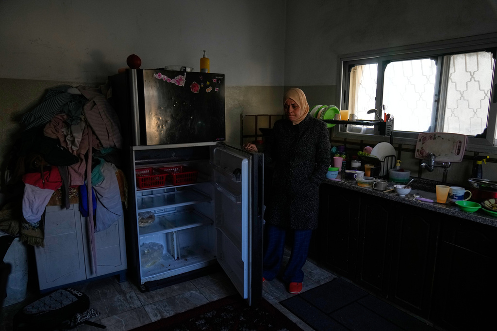 Palestinian laborer Shuhrat Barghouthi shows her empty fridge, saying that she struggles to buy food after Israel revoked work permits for Palestinians in the West Bank city of Tulkarem Sunday, Jan. 18, 2026. (AP Photo/Nasser Nasser)