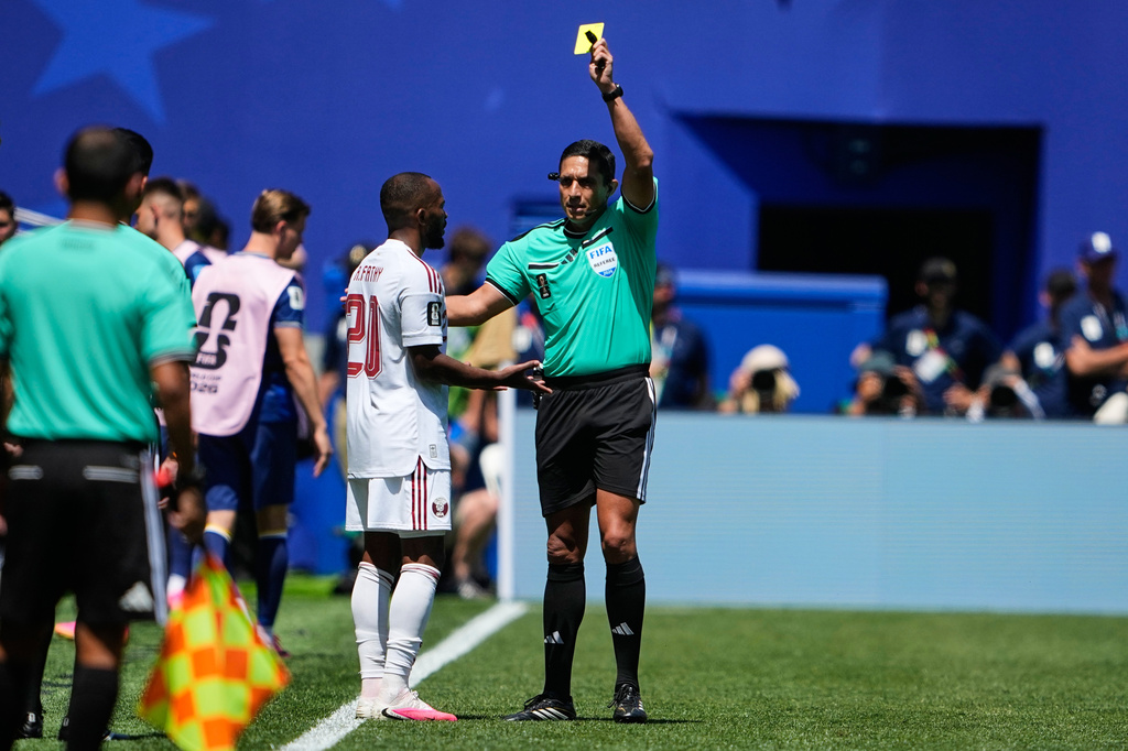 Referee Jesús Valenzuela, right, shows Qatar's Ahmed Fathy a yellow card during the World Cup Group B soccer match against Bosnia in Seattle, Wednesday, June 24, 2026. (AP Photo/Lindsey Wasson)