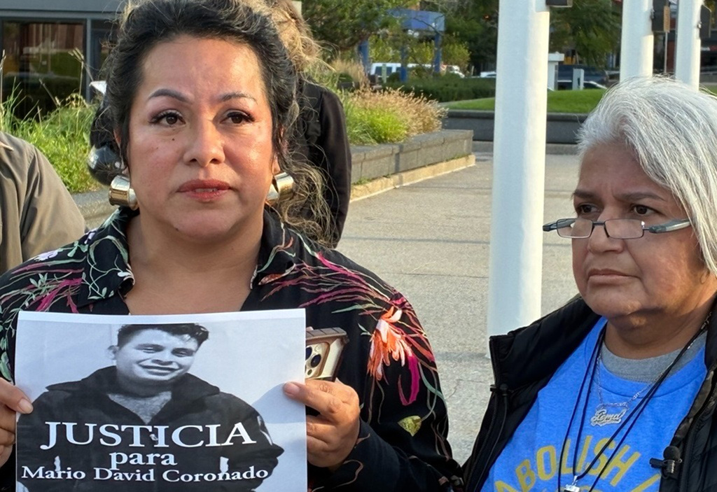 In this photo taken with a smartphone, Karla Barberi, left, and Gema Lowe demand justice Thursday, Sept. 24, 2026, for Mario David Coronado Juarez, who died in a car crash while fleeing ICE officers Sunday, Sept. 20 in Grand Rapids, Ill. (John Agar/The Grand Rapids Press via AP)