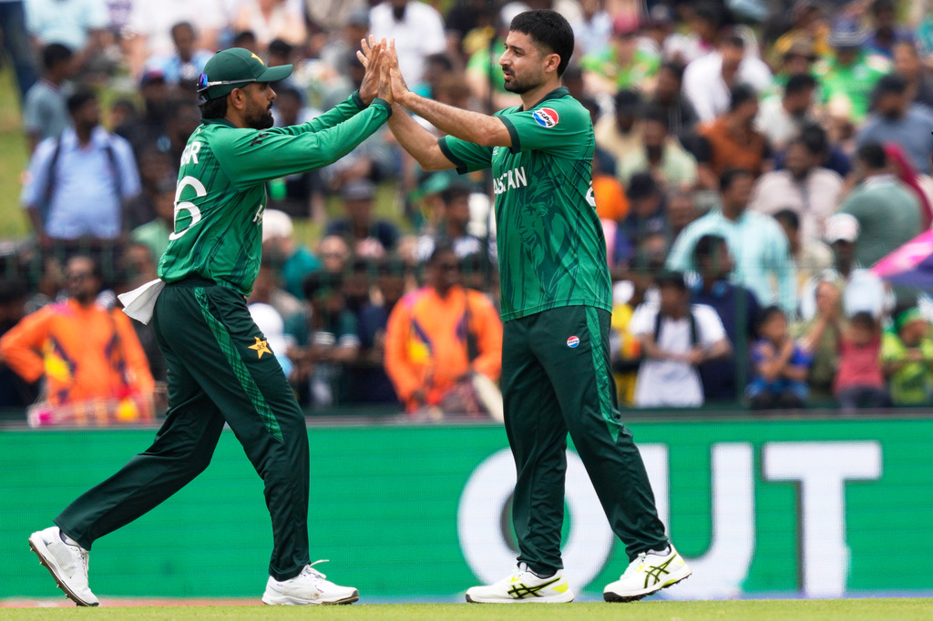 Pakistan's Abrar Ahmed, right, and teammate Babar Azam celebrate the wicket of Netherlands' captain Scott Edwards during the T20 World Cup cricket match between Netherlands and Pakistan in Colombo, Sri Lanka, Saturday, Feb. 7, 2026. (AP Photo/Eranga Jayawardena)