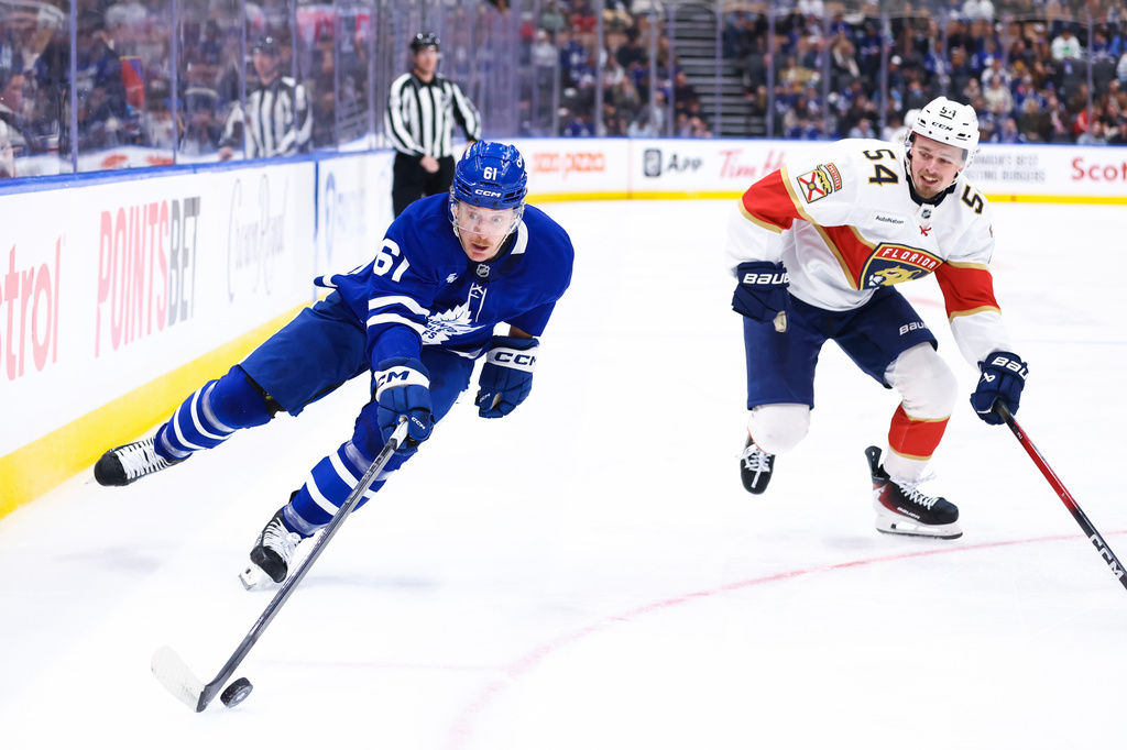 Toronto Maple Leafs' Michael Pezzetta (61) skates the puck past Florida Panthers' Ludvig Jansson (54) during second period NHL action in Toronto on Saturday, April 11, 2026. (Cole Burston/The Canadian Press via AP)