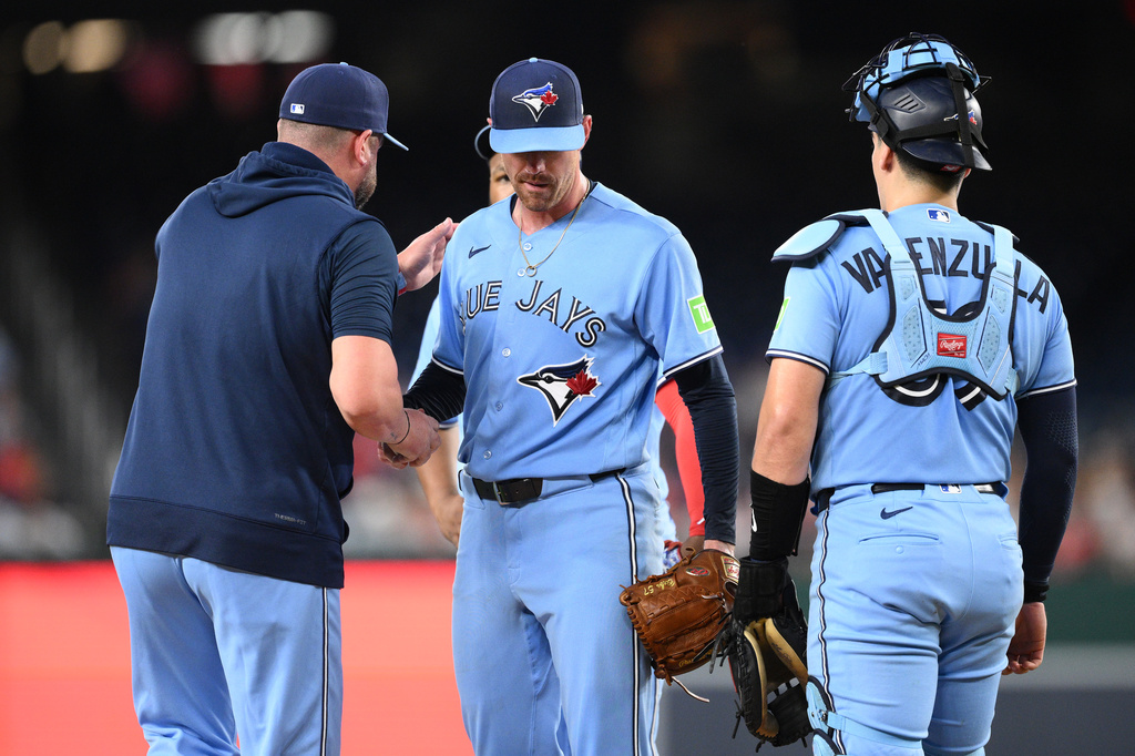 Toronto Blue Jays starting pitcher Shane Bieber, center, is pulled by manager John Schneider, left, during the first inning of a baseball game against the Washington Nationals, Tuesday, July 28, 2026, in Washington. (AP Photo/Nick Wass)