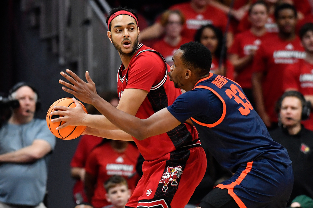 Louisville center Aly Khalifa (15) looks for help from the defense of Virginia center Ugonna Onyenso (33) during the first half of an NCAA college basketball game, in Louisville, Ky., Tuesday, Jan. 13, 2026. (AP Photo/Timothy D. Easley)