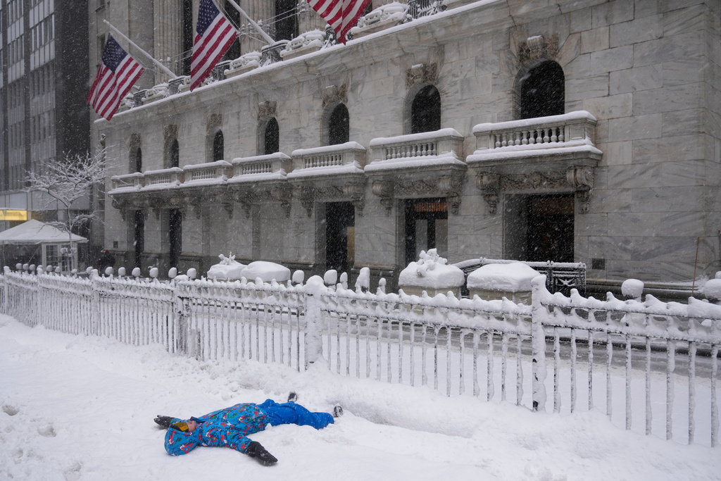 Pierce Harvey, 13, plays in the snow outside the New York Stock Exchange during a snow storm, Monday, Feb. 23, 2026, in New York. (AP Photo/Seth Wenig)
