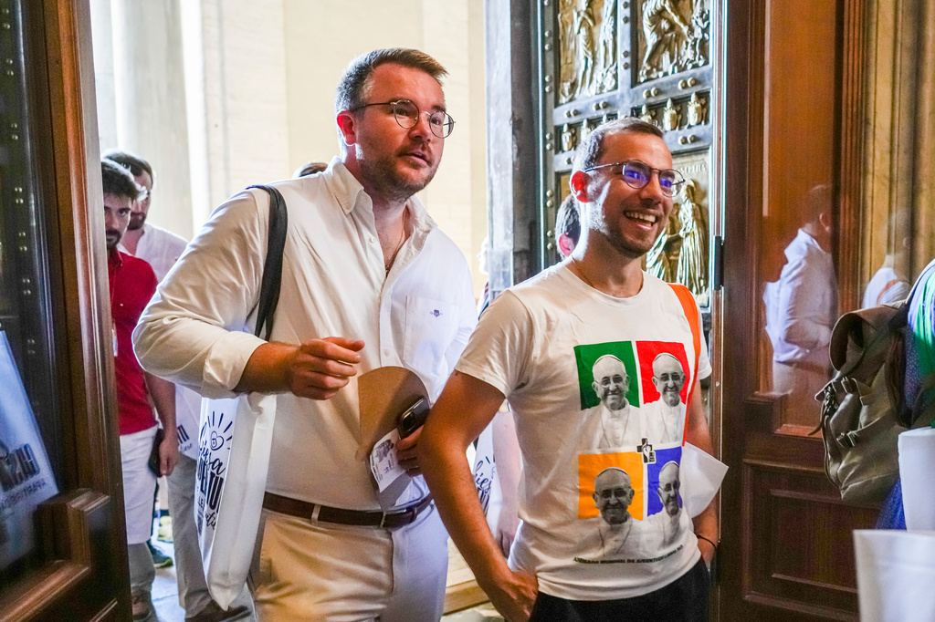 FILE - Members of the LGBTQ+ Catholics and their families who joined a Holy Year pilgrimage to Rome walk through the Holy Door of St. Peter's Basilica at the Vatican, Saturday, Sept. 6, 2025. (AP Photo/Andrew Medichini, File)