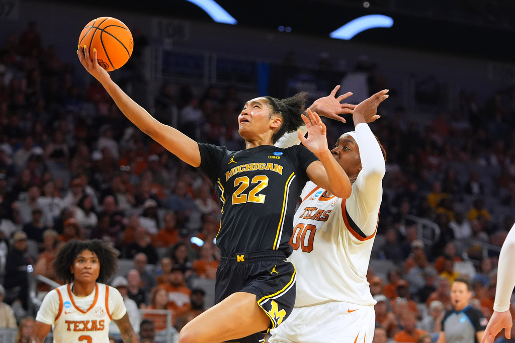 Michigan forward Kendall Dudley (22) drives on Texas center Kyla Oldacre (00) during the first half in the Elite Eight of the NCAA college basketball tournament, Monday, March 30, 2026, in Fort Worth, Texas. (AP Photo/LM Otero)