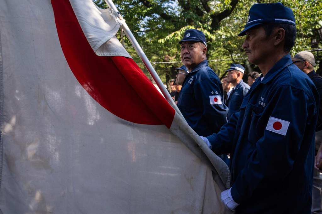 Visitors dressed up line up to offer prayers at the Yasukuni Shrine on the 80th anniversary of Japan's surrender in World War II, in Tokyo, Friday, Aug. 15, 2025. (AP Photo/Louise Delmotte)
