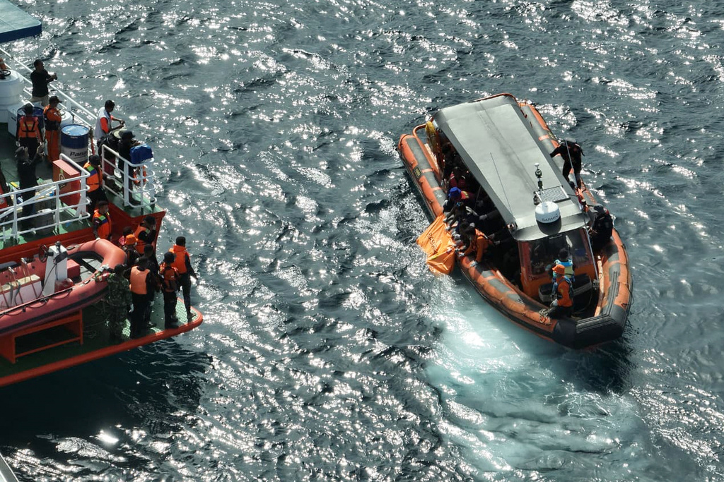 In this photo released by the Indonesian National Search and Rescue Agency (BASARNAS) on Sunday, Jan. 4, 2026, rescuers recover a body believed to be one of the victims of a tourist boat that sank on Dec. 26, in the waters near Padar Island in Komodo National Park, Indonesia. (BASARNAS via AP)