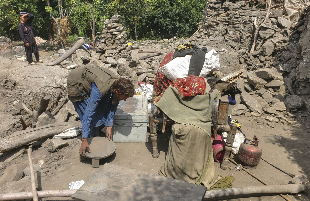 A man collects belongings from the rubble of a collapsed house after a powerful earthquake struck eastern Afghanistan on Sunday, killing many people and destroying villages, in Mazar Dara, Kunar province, Afghanistan, Wednesday, Sept. 3, 2025. (AP Photo/Hedayat Shah)