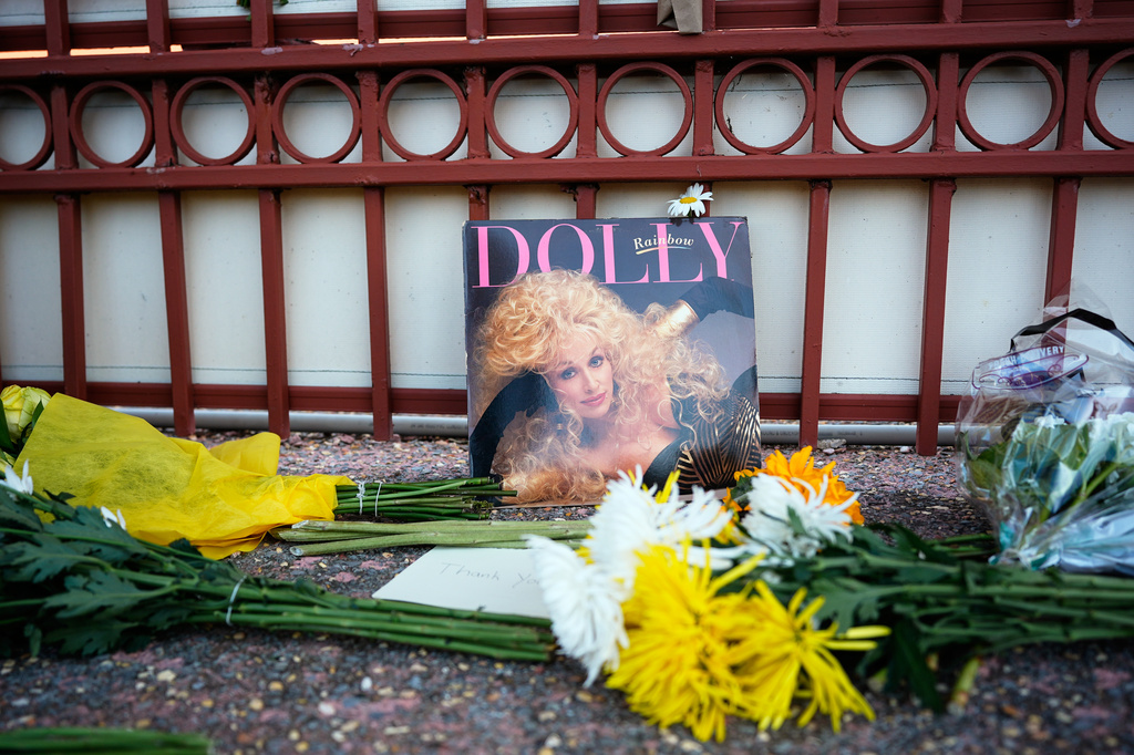 An album and flowers are left outside Dolly Parton's office on Tuesday, Aug. 25, 2026, in Nashville, Tenn. (AP Photo/George Walker IV)
