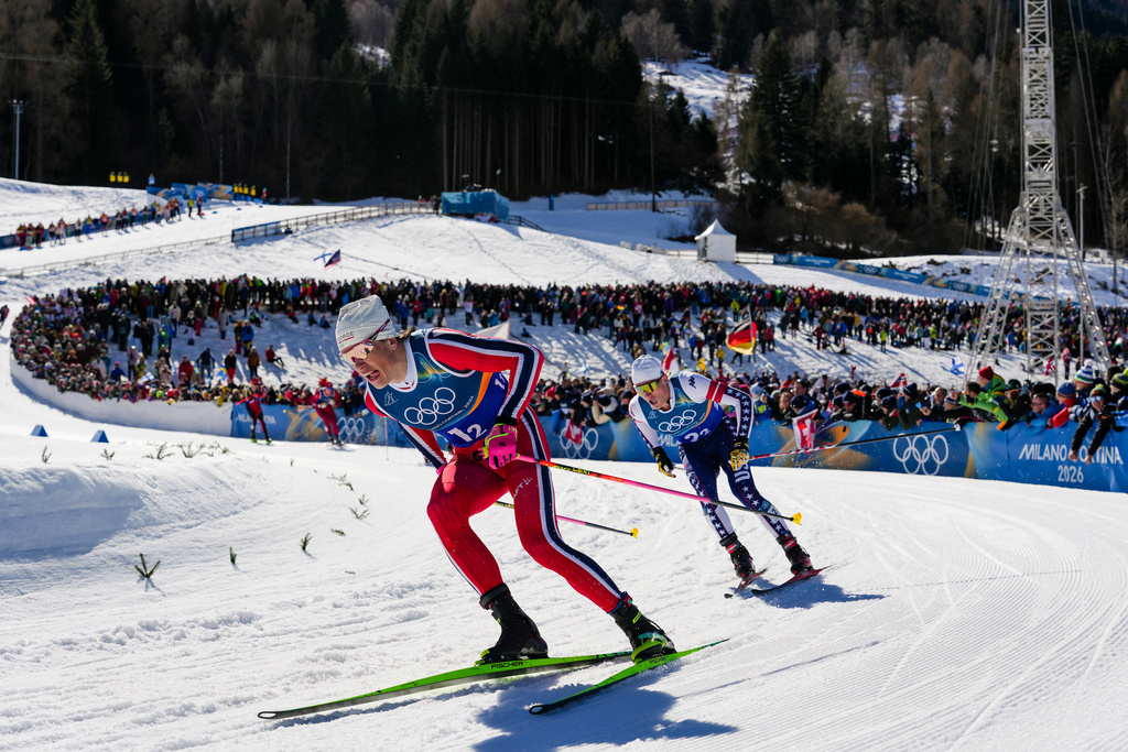 Johannes Hoesflot Klaebo, of Norway, and Gus Schumacher, of the United States, right, compete in the cross-country skiing men's team sprint free at the 2026 Winter Olympics, in Tesero, Italy, Wednesday, Feb. 18, 2026. (AP Photo/Evgeniy Maloletka)