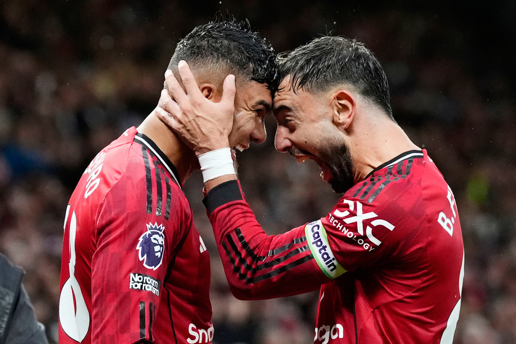 Manchester United's Casemiro, left, celebrates with Bruno Fernandes after scoring their second goal during the English Premier League soccer match between Manchester United and Chelsea at the Old Trafford stadium in Manchester, England, Saturday, Sept. 20, 2025. (Nick Potts/PA via AP)