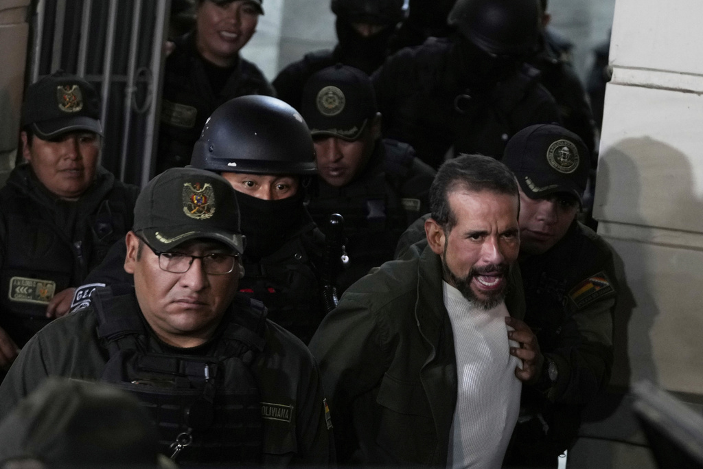 Former governor of Santa Cruz Luis Fernando Camacho is escorted by police as he leaves a court hearing regarding the length of his pretrial detention stemming from the crisis over the 2019 ouster of former President Evo Morales, in La Paz, Bolivia, Aug. 26, 2025. (AP Photo/Juan Karita)